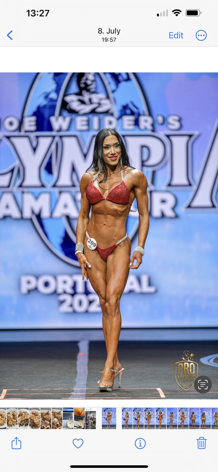 Nieves García on stage in a red competition bikini at Olympia Amateur Portugal